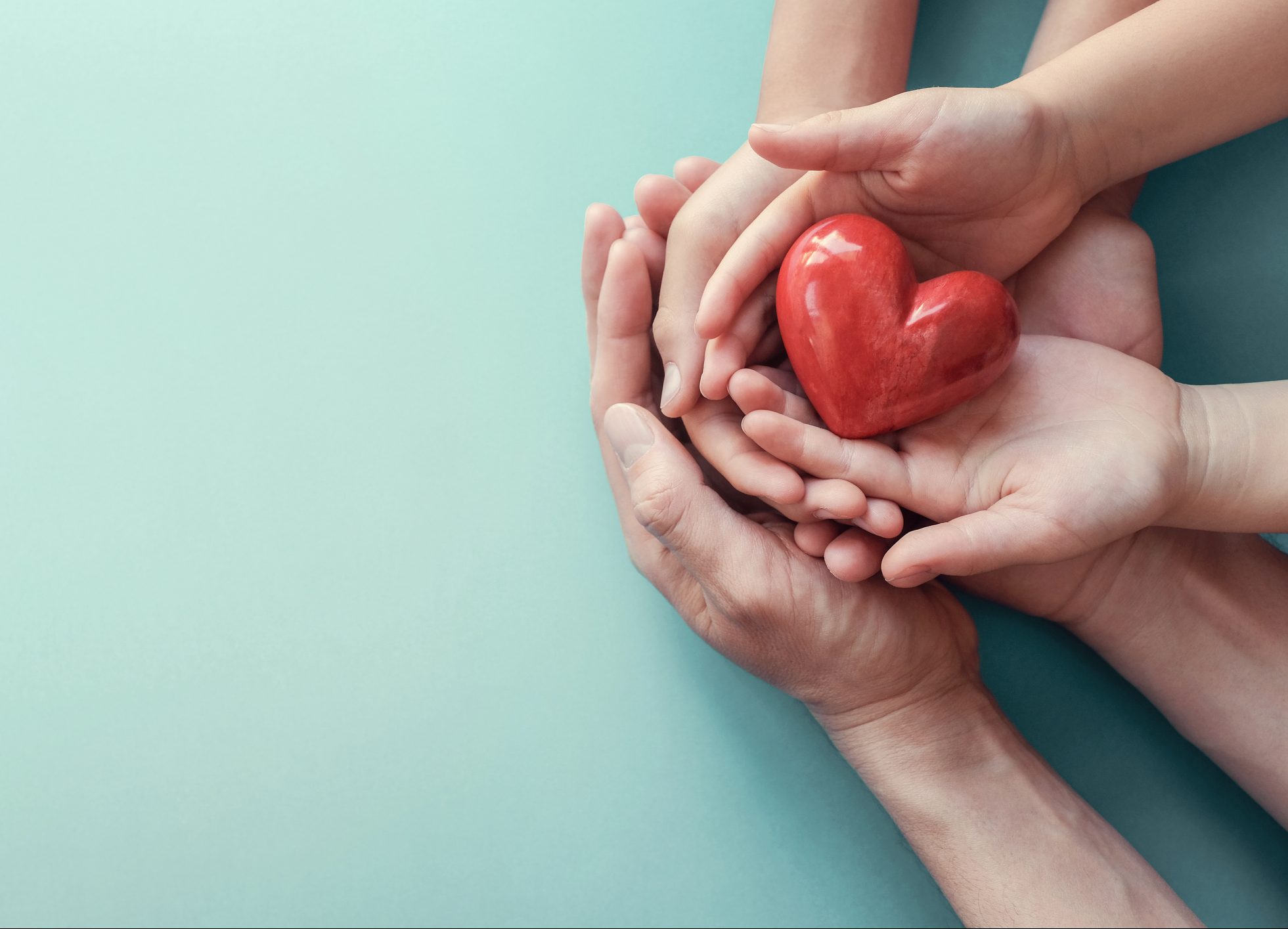 FUNIBER-adult-and-child-hands-holding-red-heart-on-aqua-background-heart-health-donation-csr-concept-world-heart-day-world-health-day-family-day